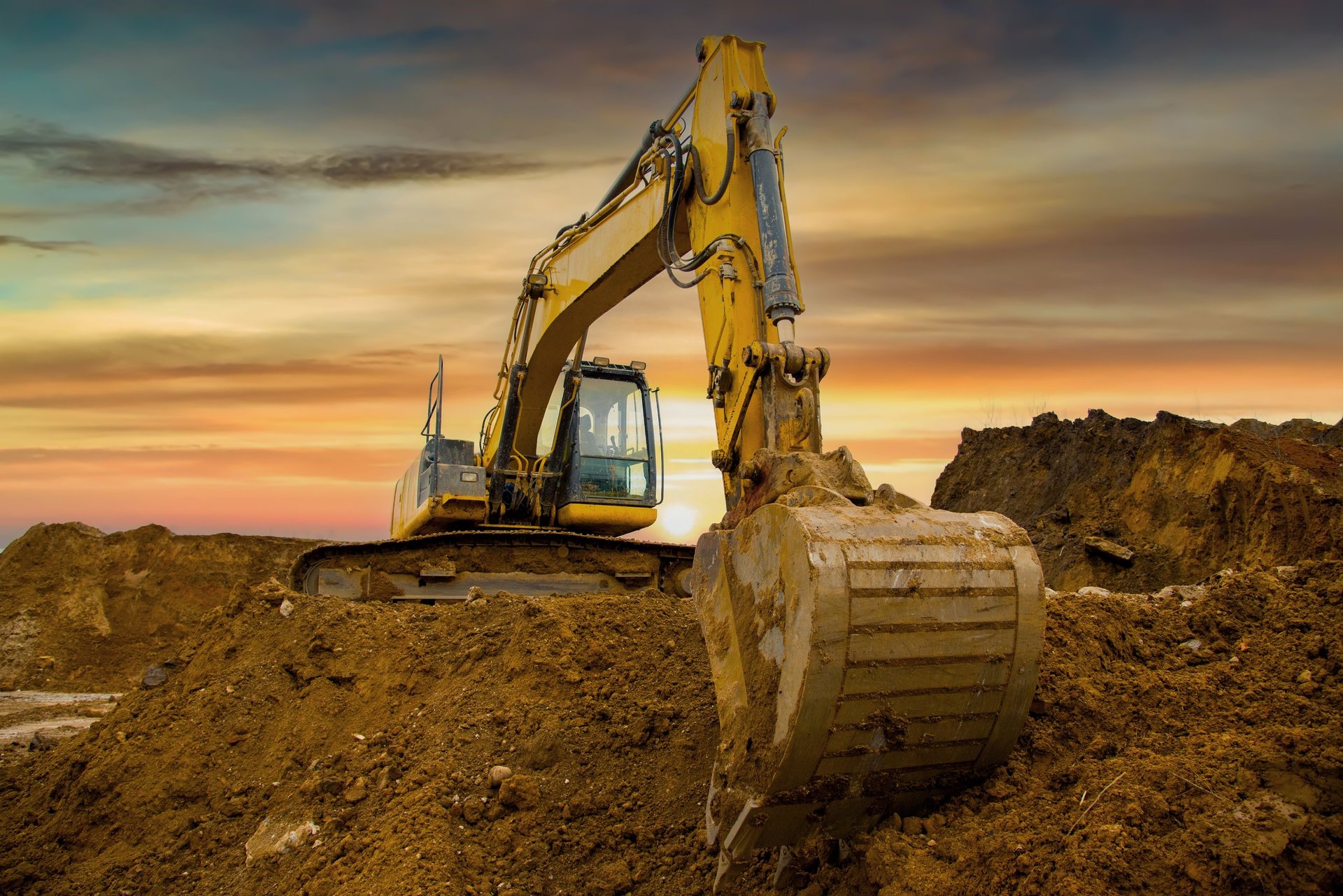 Excavator on sunset in open-pit mining